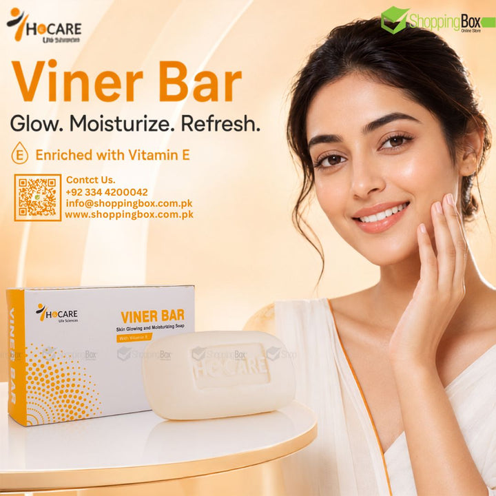 A woman with a radiant smile touches her cheek beside a boxed and wrapped Viner Bar skincare product on a light table. The ad includes the HOCARE brand logo, product text, contact details, and a Shopping Box watermark on a warm beige background.